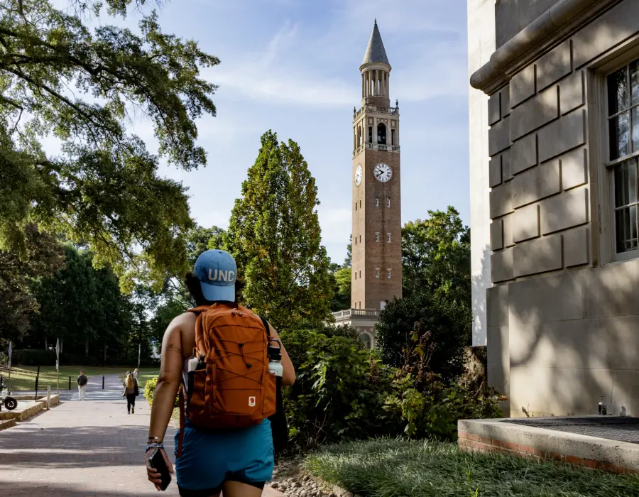 Student walking toward the Morehead-Patterson Bell Tower