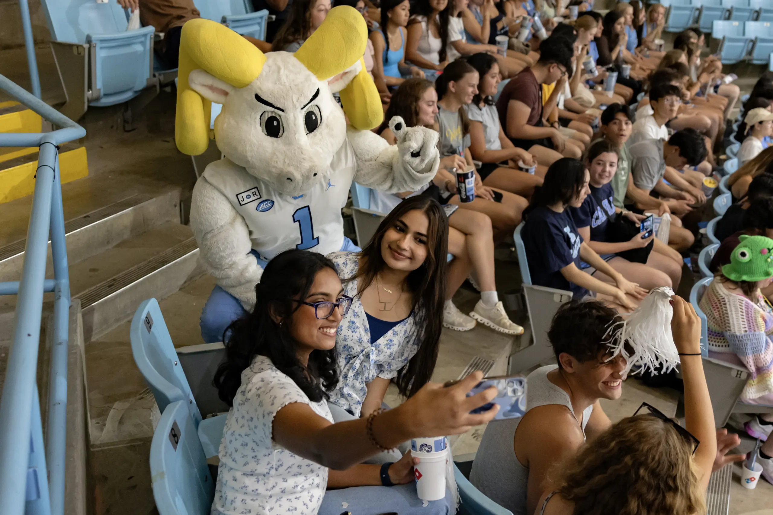 Students taking a selfie with Ramses at a campus pep rally